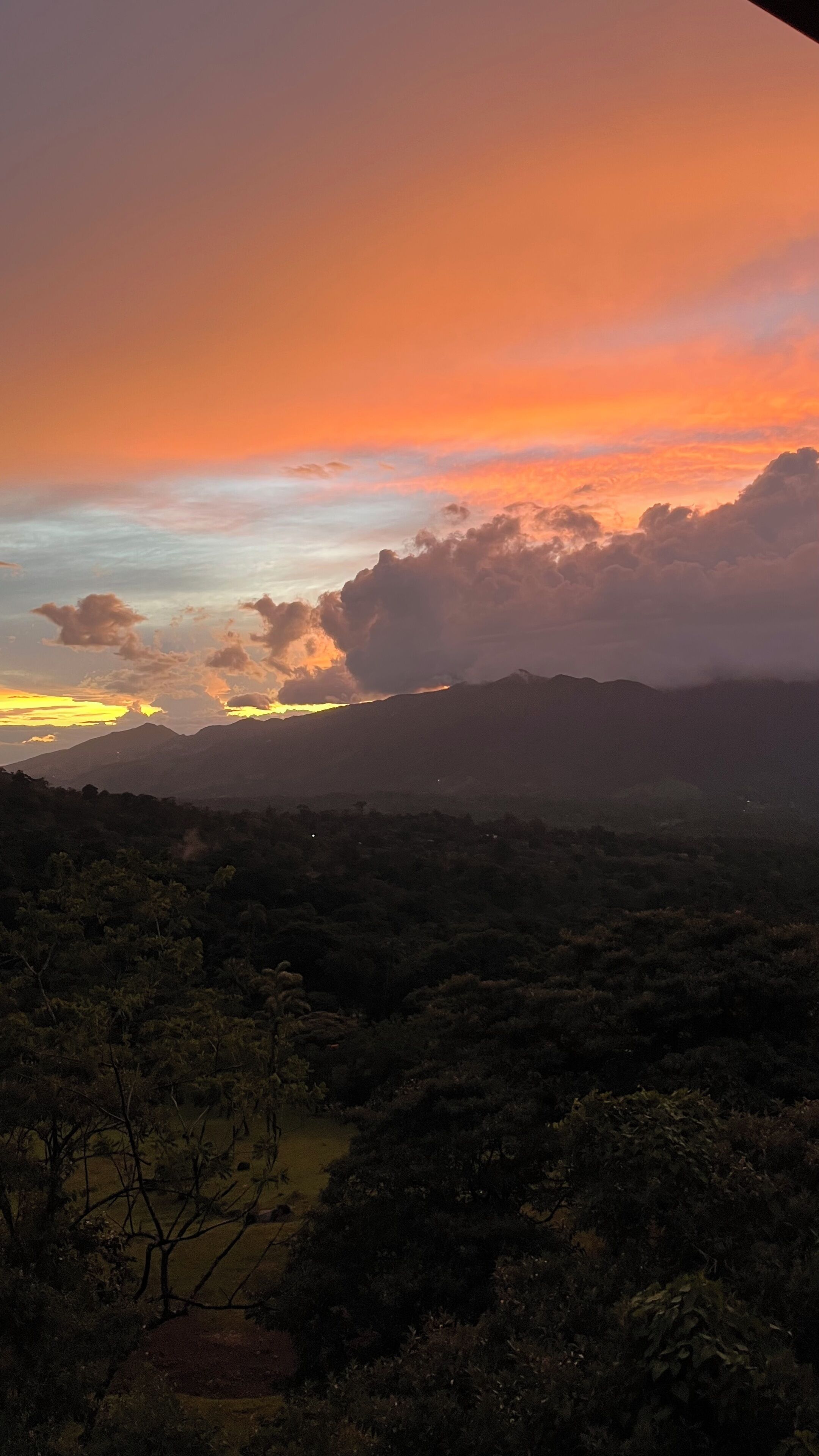 A landscape with a sunset over a mountainous area.