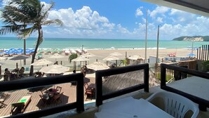 Un ristorante sulla spiaggia con posti a sedere all'aperto e vista sull'oceano.