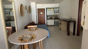 Una cucina moderna con mobili bianchi, un forno a microonde e un piano cottura a gas.