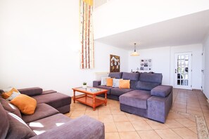 Un salon comprenant un canapé, une table basse et un tableau accroché au mur.