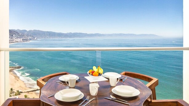 Una mesa de comedor con vista al océano y a la playa.