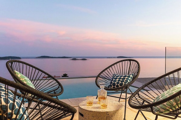 Relax in a serene outdoor setting with a tranquil view, perfect for unwinding with a drink.