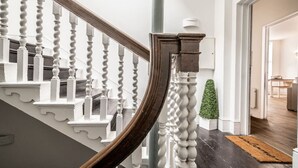 A staircase with white balusters and a dark wooden handrail. - Stylish and bright City Centre apartment (Exeter)