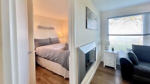 A bedroom with a bed, bedside table, lamp, and a TV. - 2 Bed Chalet with Rural Views (Dartmouth)