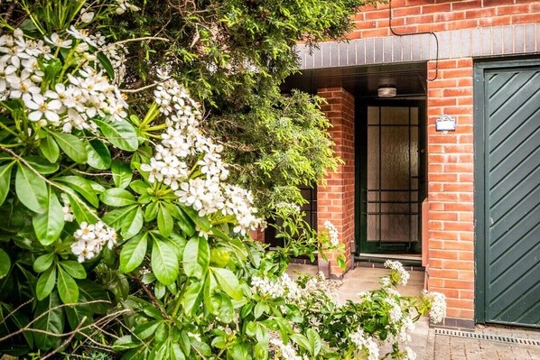 Set amidst lush greenery, this charming property features an entrance with a green door.