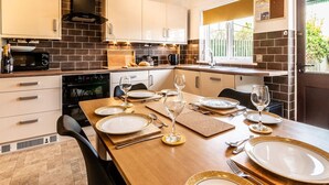 A modern kitchen with a dining area set for a meal. - Stylish townhouse by the Quay with parking (Exeter)