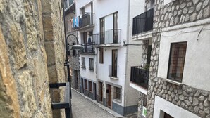 A narrow cobblestone street flanked by stone and plaster buildings with balconies. - HOSTAL MARBORE (Bielsa)