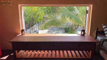 Un banco de madera con vista a un jardín y palmeras.