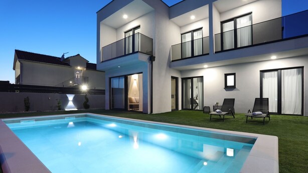 A modern two-story building with a swimming pool and outdoor seating area. - Villa Cvit Mediterana with heated pool (Poljica-Brig)