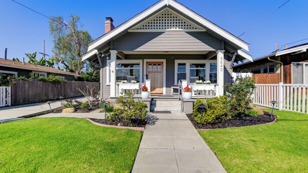 Una casa de dos pisos con un porche delantero, el número '3640' visible en el lateral y un césped bien cuidado.