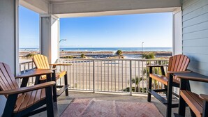 A balcony with wooden chairs and a view of the beach. - Grand Caribbean 312 2 Bed 2 Bath - Great View! (Orange Beach)