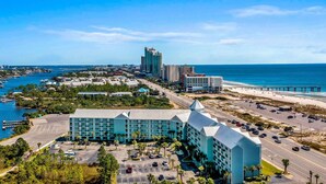 A coastal hotel with multiple buildings, a parking lot, and a view of the ocean and beach. - Grand Caribbean 312 2 Bed 2 Bath - Great View! (Orange Beach)