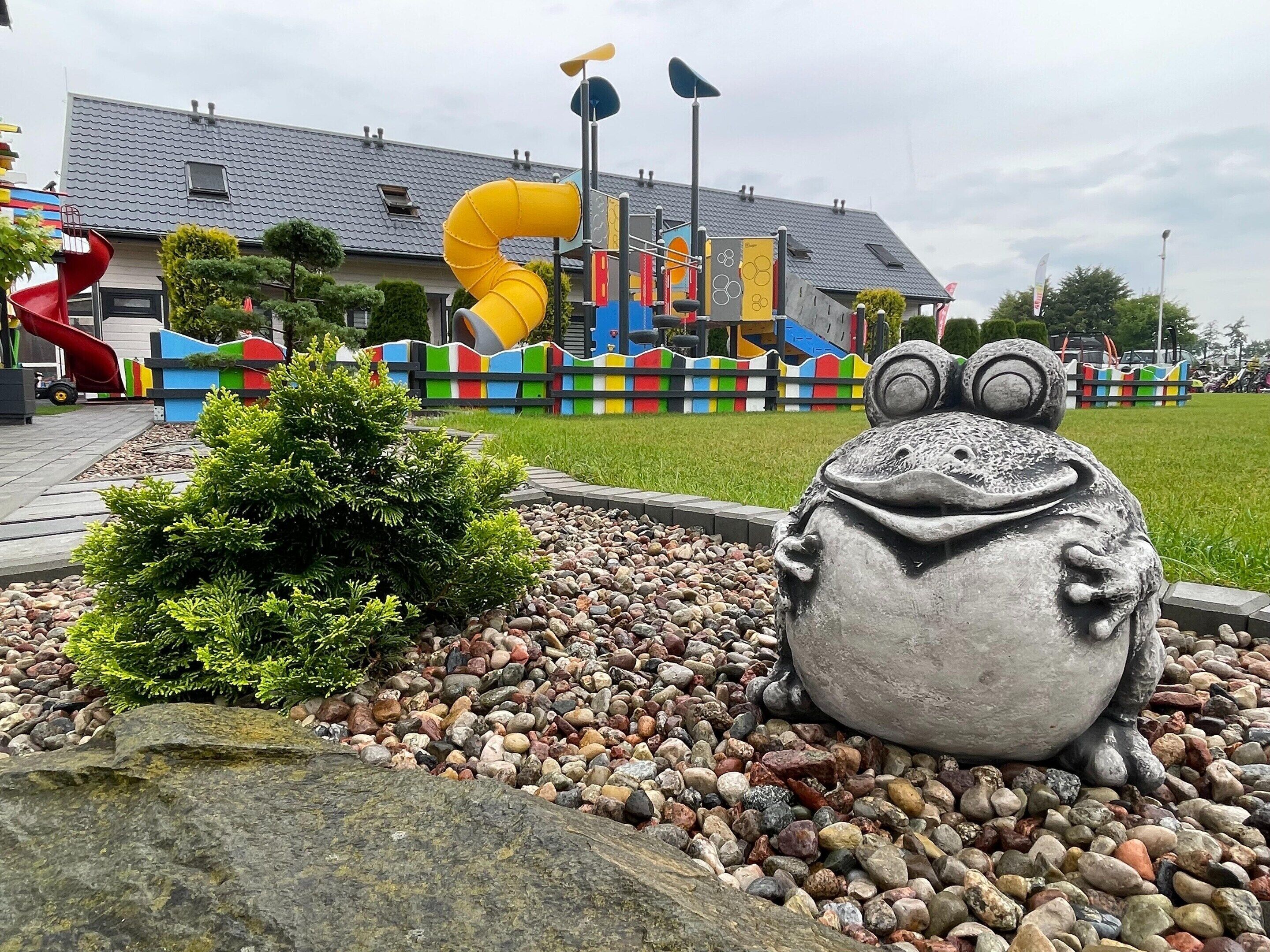 En lekplats med rutschkanor och en grodstaty.