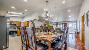Un comedor espacioso con una mesa de madera dispuesta para seis personas, rodeada de sillas de cuero.