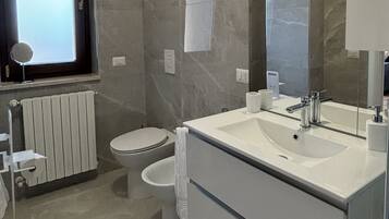 Een douche, een haardroger, een bidet, handdoeken