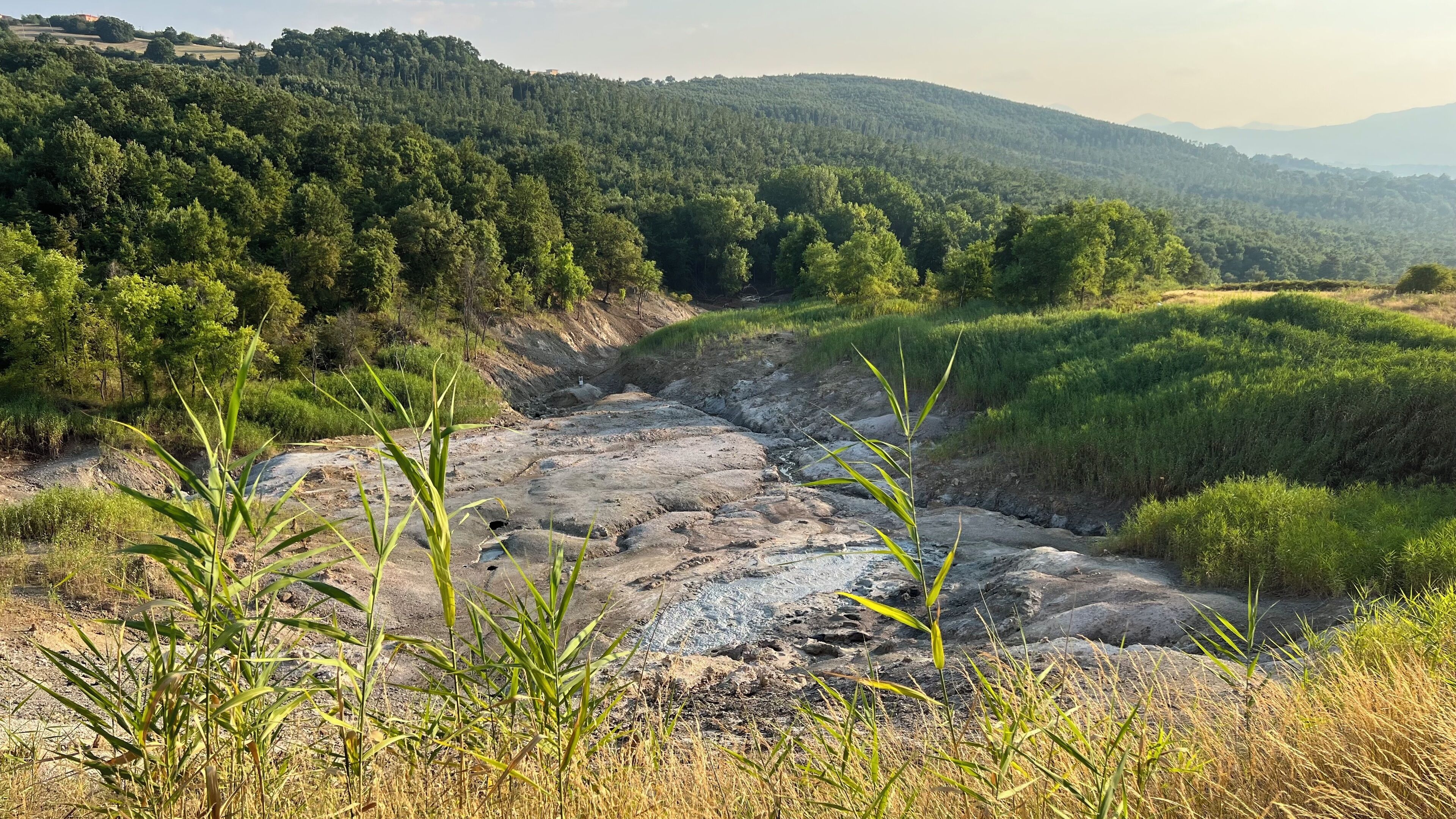 A natural landscape with a river, rocky terrain, and dense forest.