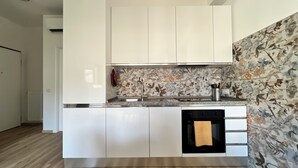 A modern kitchen with white cabinets, a stainless steel sink, and a patterned backsplash. - Rocchesi Apartments - Studio apartment with portion of terrace, ideal for couples (Rocca San Felice)