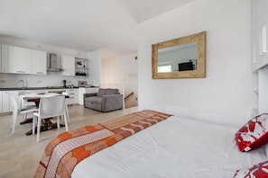 A modern bedroom with a large bed, a bedside table, and a chair.