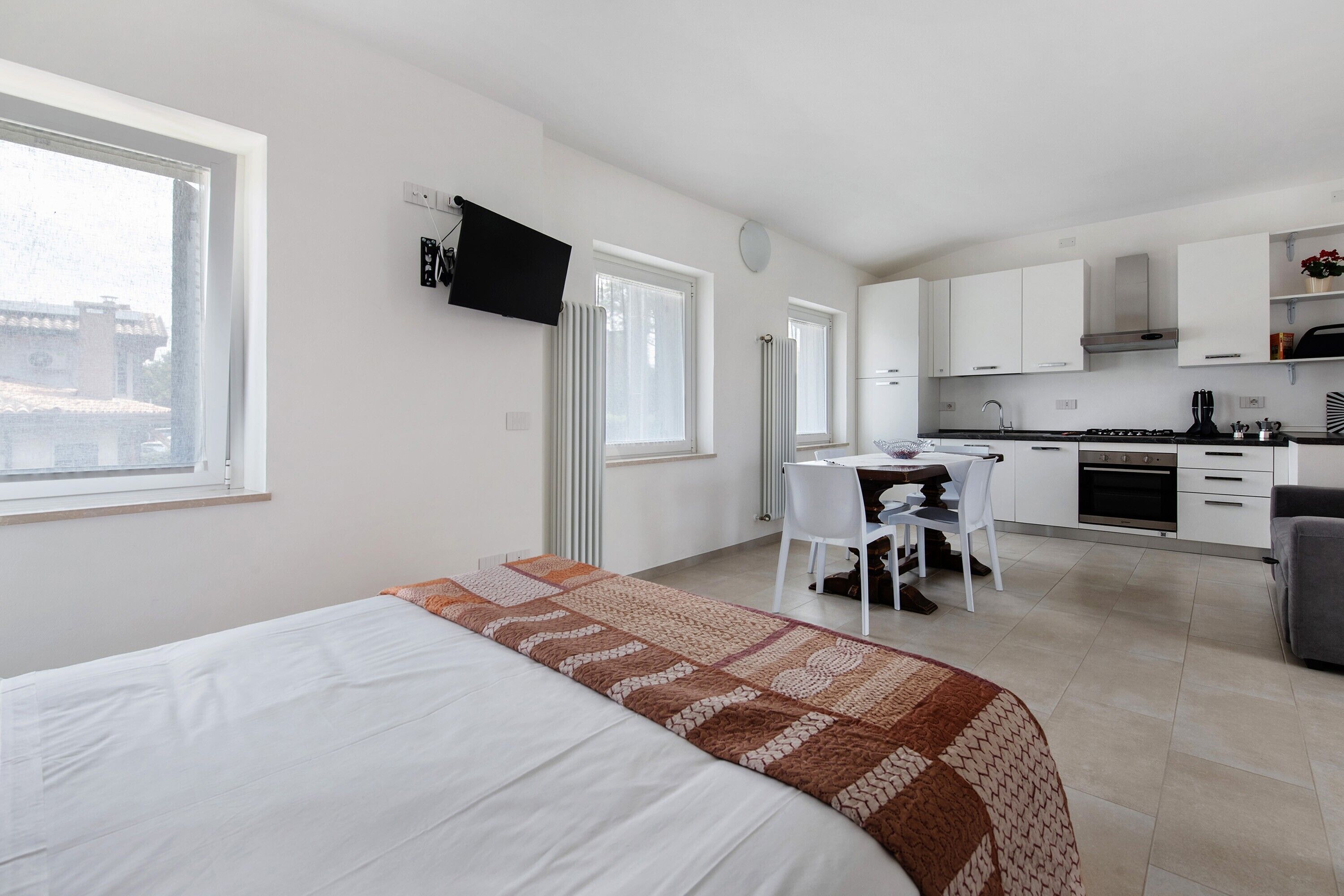 Une chambre moderne équipée d’un lit, d’un bureau et d’une kitchenette.