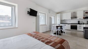 Une chambre moderne équipée d’un lit, d’un bureau et d’une kitchenette.