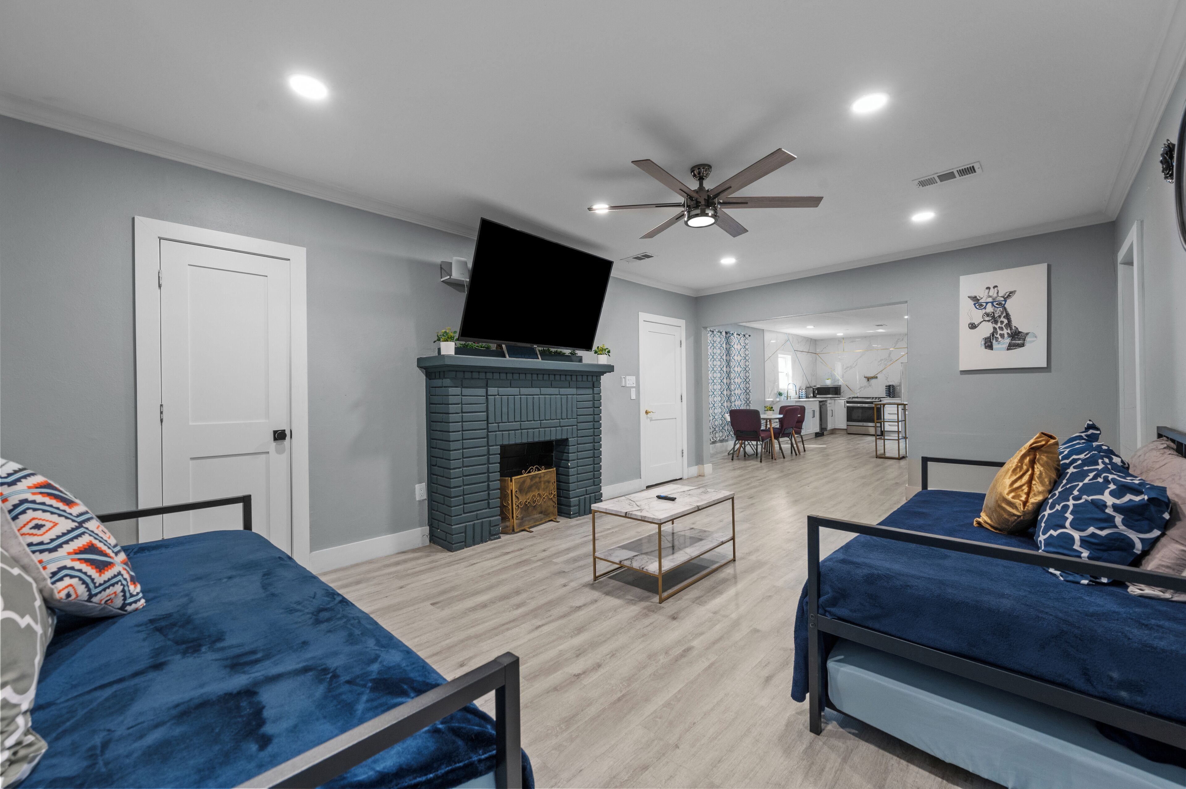 A modern living room with a fireplace, two sofas, a coffee table, and a television.