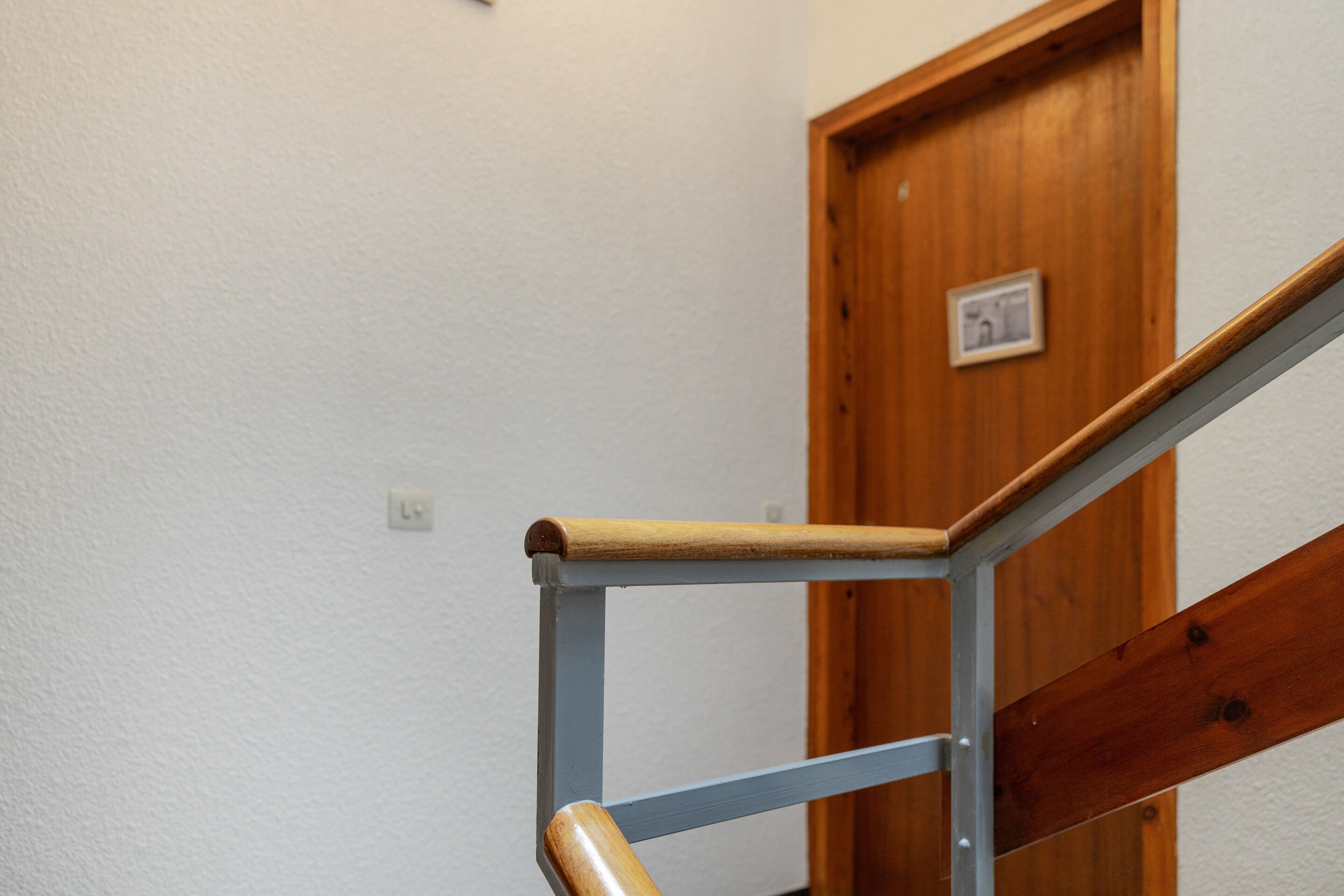 Une main courante en bois et une rampe d’escalier en métal.