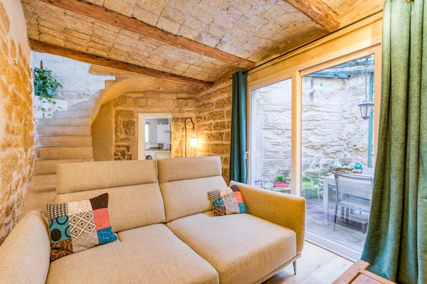 Une pièce confortable avec un canapé, un escalier et une vue sur l’extérieur.