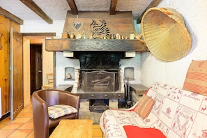 A rustic room with a fireplace, wooden furniture, and a woven basket.