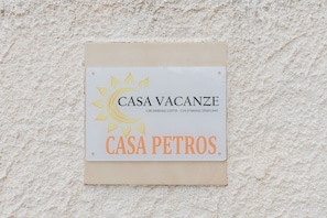 A sign with the text 'CASA VACANZE' and 'CASA PETROS' on a textured wall. - Room 'Giovanna' with Shared Terrace, Wi-Fi and Air Conditioning (Marsala)