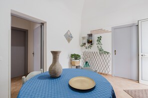 A dining area with a blue checkered tablecloth, a large woven vase, and a decorative plate. - Holiday Home 'Petros' with Shared Terrace, Wi-Fi and Air Conditioning (Marsala)