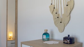 Una mesita de noche de madera con una botella de líquido y un adorno.