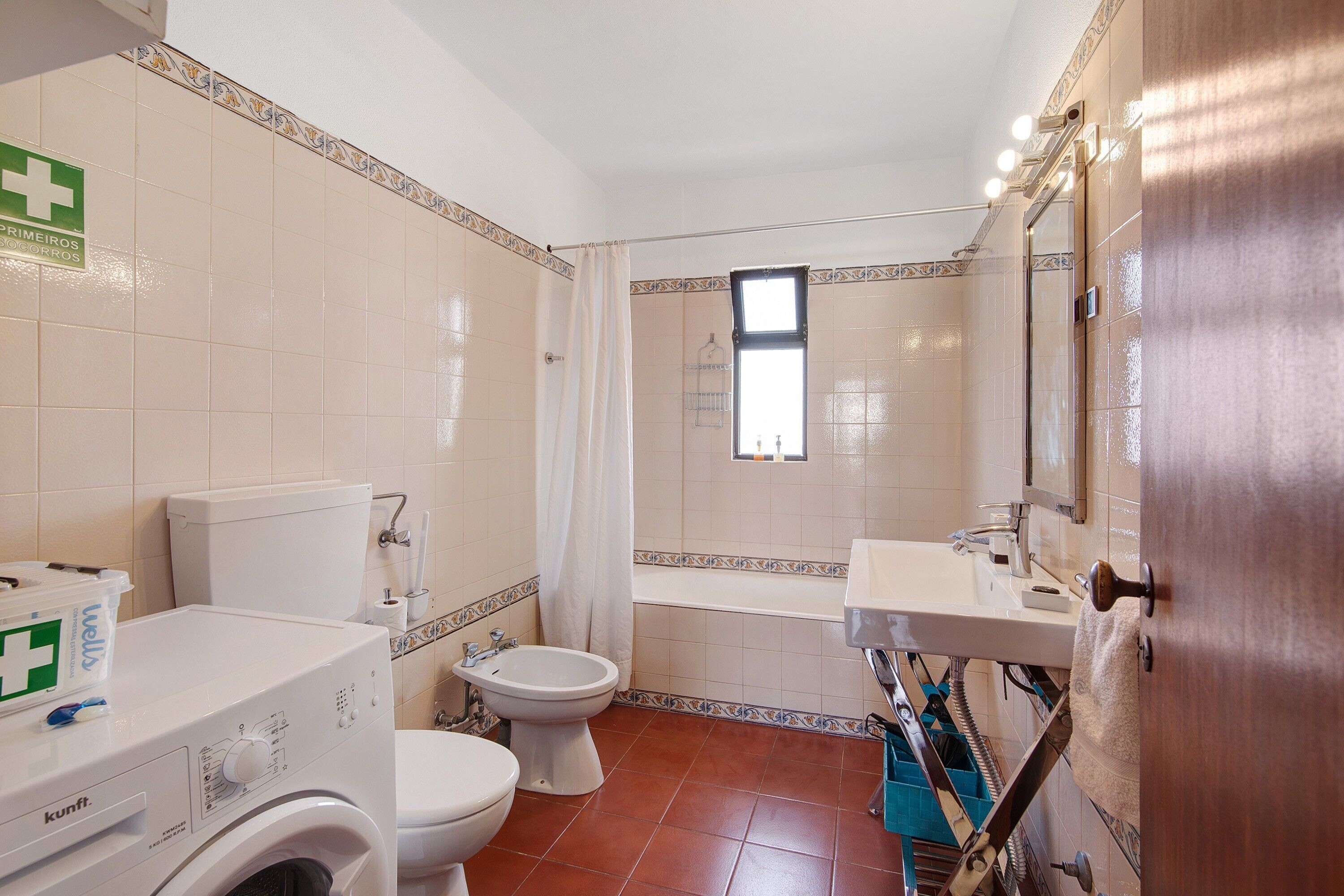 Une salle de bain comprenant des toilettes, un bidet, un lave-linge et un lavabo.