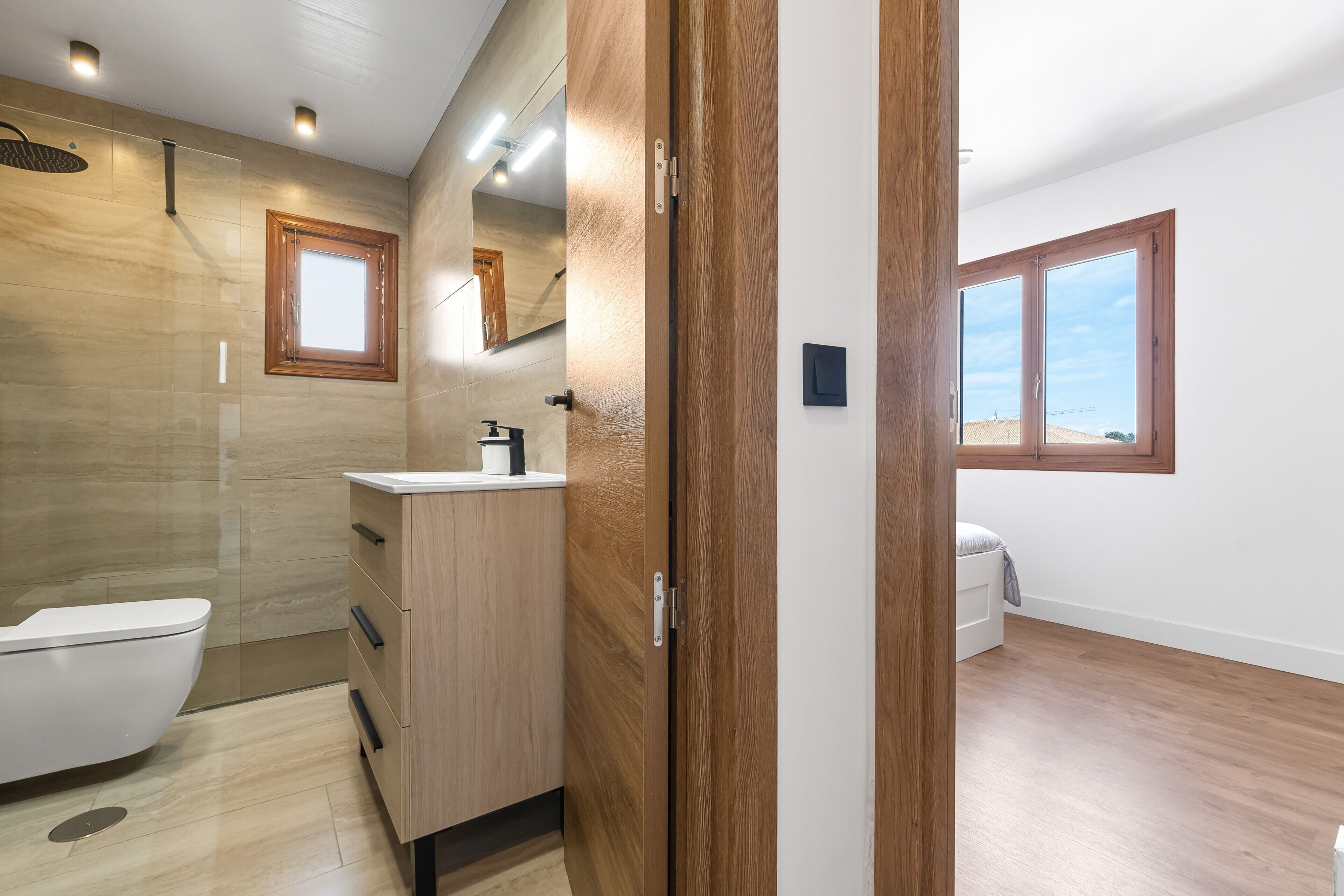 Une salle de bain moderne équipée de toilettes, d’un meuble-lavabo et d’une douche.