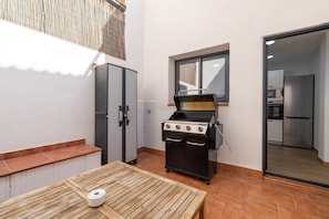 Une cuisine de taille réduite, équipée d’une cuisinière à gaz, d’un réfrigérateur et d’une fenêtre.