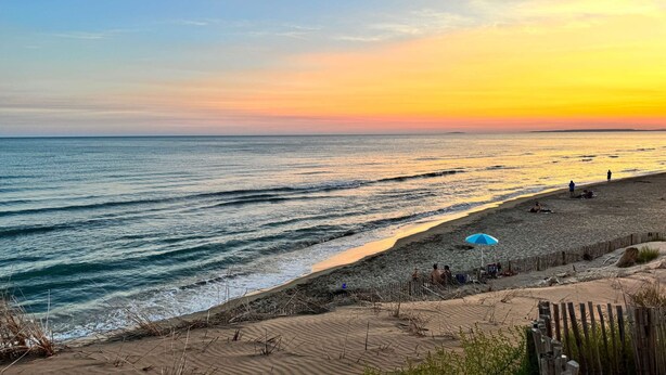 A beach with waves, a sunset, and people. - Spacious 3 room air-conditioned apartment terrace garage (LE GRAU DU ROI)