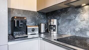 Une cuisine moderne équipée d’une machine à café, d’un grille-pain et d’une cafetière.