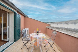 An outdoor patio with a table set for two, a bottle of wine, and two glasses. - Room 'Cabernet R12' with Shared Pool, Wi-Fi and Air Conditioning (Siracusa)