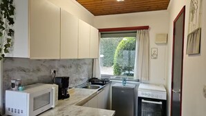 A compact kitchen with white cabinets, a microwave, a coffee maker, a sink, a refrigerator, and an oven. - Nawal's Belle Vue Dinant/Givet (Hastière)