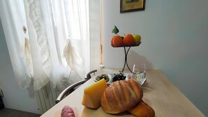 A dining table with a variety of food items, a cutting board with a vegetable, and a chair. - Apartment 'A Matrice' with Balcony, Wi-Fi and Air Conditioning (Barrafranca)