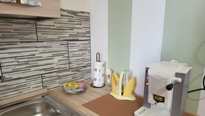 A kitchen with a stainless steel sink, a coffee machine, and a paper towel holder. - Apartment 'A Matrice' with Balcony, Wi-Fi and Air Conditioning (Barrafranca)