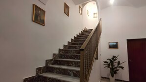 A marble staircase with a wooden handrail leading to a landing. - Apartment 'A Matrice' with Balcony, Wi-Fi and Air Conditioning (Barrafranca)