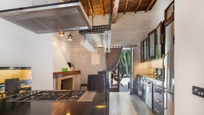 A modern kitchen with a central island, stainless steel appliances, and a view to the outdoors. - Beautiful luxury villa in Ibiza with Wi-Fi and air conditioning (Illes Balears)
