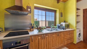 Una cocina con estufa, horno, microondas y lavadora integrados.