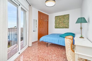 Una camera da letto con un letto, una scrivania, una sedia, una finestra e una porta.