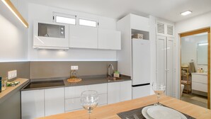 A modern kitchen with white cabinets, a built-in microwave, and a sink. - Vacation Apartment 'Sun and Serenity Pool Wifi' with Sea View, Wi-Fi and Air Conditioning (Puerto Rico)