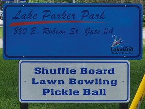 A sign for Lake Parker Park, including a shuttle board, lawn bowling, and pickle ball.