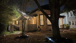 A house with a brick exterior, a porch, and string lights.