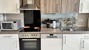 Una cocina moderna equipada con microondas, estufa, horno y lavavajillas.