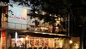 Un immeuble de deux étages abritant un restaurant au rez-de-chaussée et un bar/salon à l’étage supérieur.