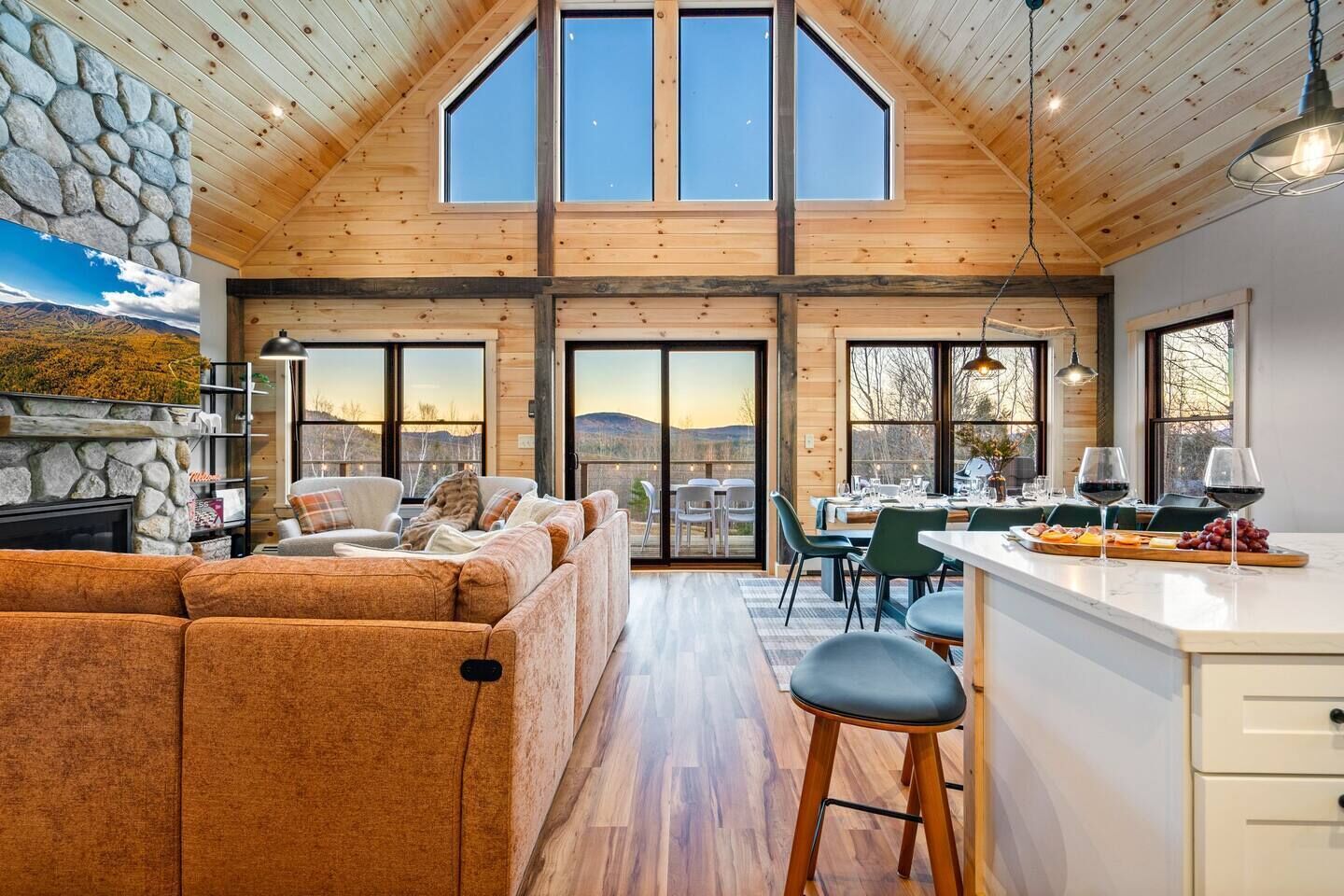 A spacious living area with a large sofa, a dining table with chairs, and a kitchen area with a bar.